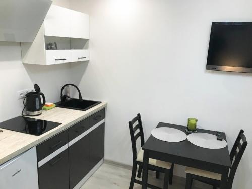 una pequeña cocina con mesa y sillas en una habitación en Apartamentai Nidos centre Taikos g, en Nida