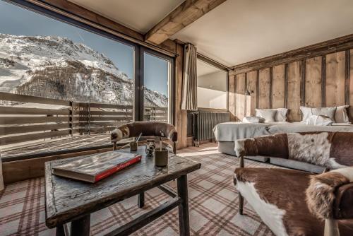 a bedroom with a bed and a table with a book at Hotel & Spa Le Val d'Isère in Val dʼIsère