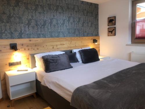 ein Schlafzimmer mit einem großen Bett mit blauer Wand in der Unterkunft Apart EMMA in Finkenberg