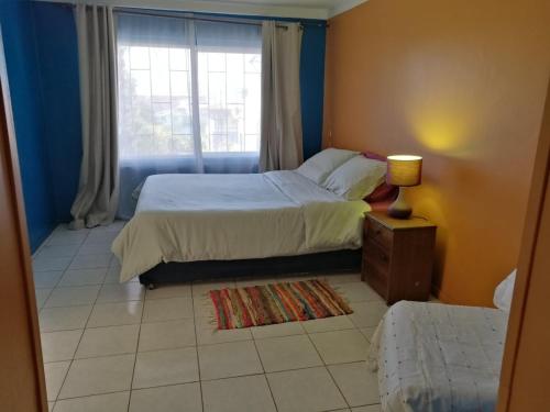 a small bedroom with a bed and a window at Hostal Maison de la Mer in Valparaíso