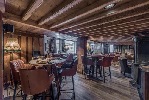 a restaurant with wooden walls and tables and chairs at Hotel & Spa Le Val d'Isère in Val dʼIsère
