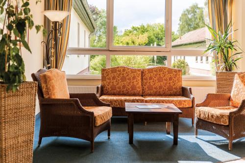 a living room with a couch and chairs and a table at Seehotel Heidehof in Klein Nemerow