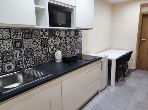 a kitchen with a sink and a counter top at Apartamenty As Szczyrk Centrum in Szczyrk