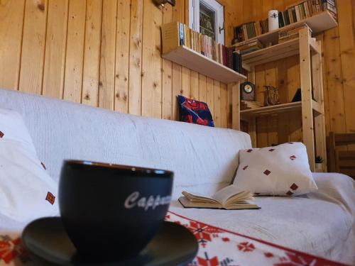 una taza de café sentada en una mesa con un libro en Casa Bando, en Moacşa