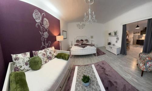 ein Wohnzimmer mit einem weißen Sofa und ein Schlafzimmer in der Unterkunft Appartment Rosengarten in Baden