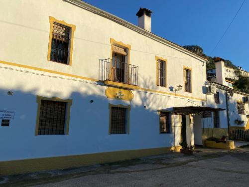 ein weißes Gebäude mit einer Veranda und einem Balkon in der Unterkunft La Buhardilla de Torrecillas in El Bosque