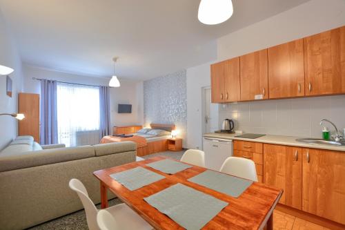 uma cozinha e sala de estar com uma mesa e um sofá em Apartdom em Krynica-Zdrój