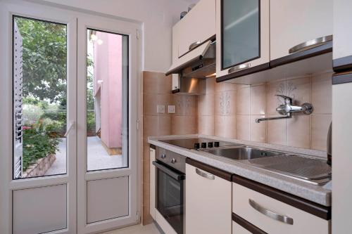 a kitchen with a sink and a window at Apartments Ena in Vrboska