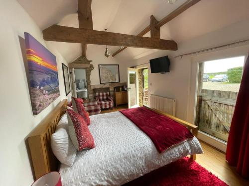 1 dormitorio con cama y ventana grande en Folly Hall Farm en Whitby