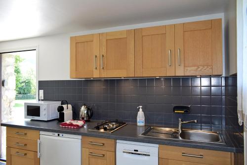 a kitchen with a sink and a microwave at Appartement Le 510 in Aigueblanche
