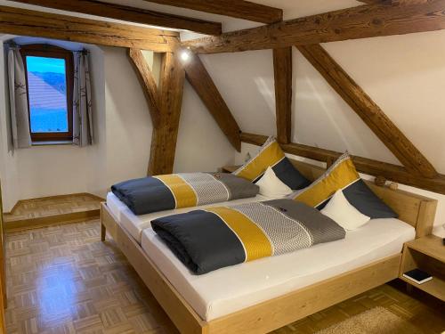 a bedroom with a bed with yellow and blue pillows at Gasthof - Pension - Adler in Weiler-Simmerberg