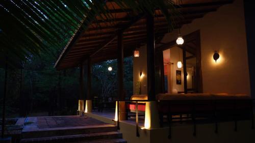 a porch of a house at night with lights at Mind Body and Soul in Dambulla