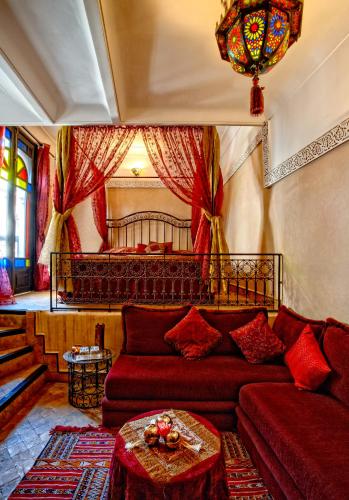 un soggiorno con un divano e un letto di Riad Basim a Marrakech