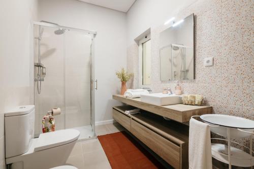 a bathroom with a sink and a toilet and a mirror at Casa Calmaria Beja in Beja