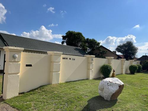 a white fence with a rock in the yard at House 210 holiday rentals in Alberton