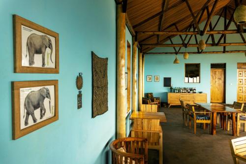 a room with a dining room with a table and chairs at Isunga Lodge in Kibale Forest National Park