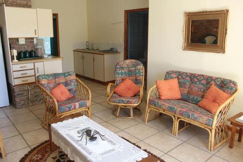een woonkamer met stoelen en een tafel bij Tulip Close in Stilbaai