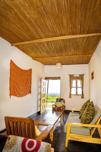 a living room with a wooden ceiling at Isunga Lodge in Kibale Forest National Park