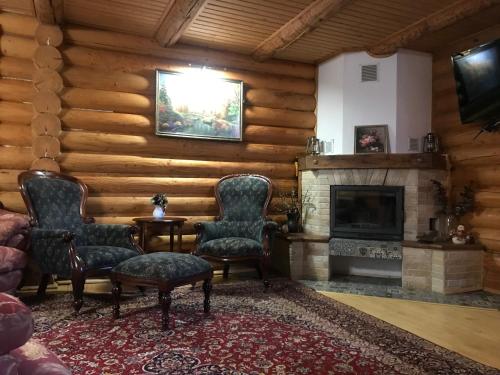 un soggiorno con due sedie e un camino di Cottage Lavanda окремий котедж з каміном a Bukovel