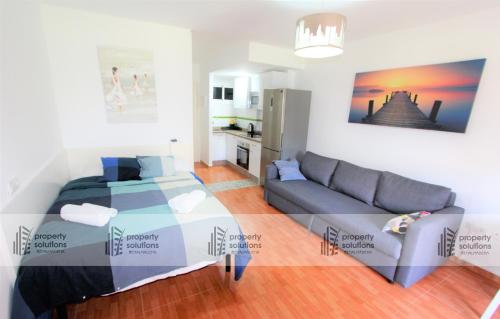 ein Wohnzimmer mit einem Bett und einem Sofa in der Unterkunft 102 Estudio en Jupiter Apartmentos - Piscina y Playa - Excelente Ubicación in Benalmádena
