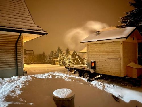 a truck parked next to a house in the snow at Miętowa Górka in Ząb