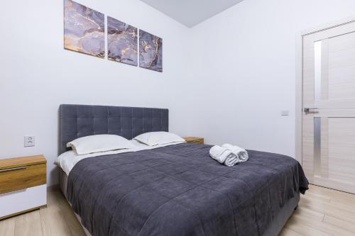 ein Schlafzimmer mit einem großen Bett mit zwei Handtüchern darauf in der Unterkunft VODNA White Apartment in Lwiw