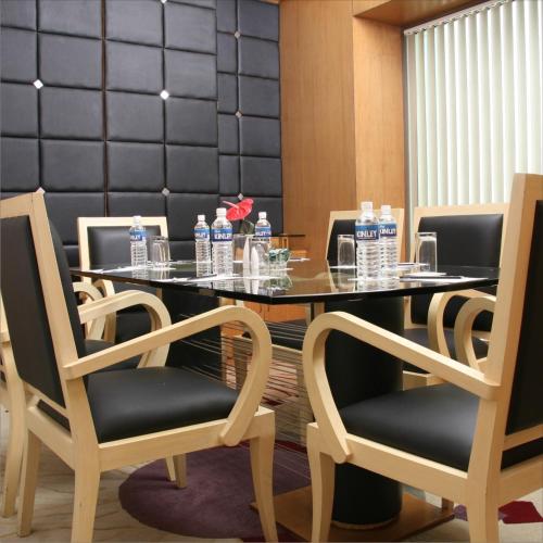 a dining room with a table and chairs with water bottles at Radisson Blu Hotel MBD Ludhiana in Ludhiana