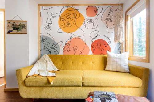 a couch in a living room with a wall with drawings on it at The Herwood Inn in Woodstock