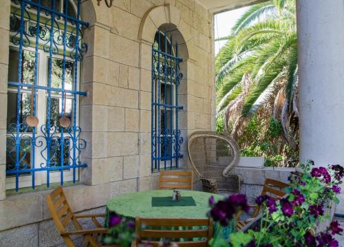a patio with a table and chairs and flowers at Jerusalem Garden Home in Jerusalem