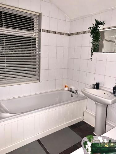 a white bathroom with a tub and a sink at Contemporary 2 Bedroom Victorian Town House - Sleeps up to 6 in Kimberley