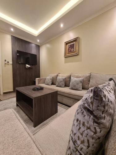 sala de estar con sofá y mesa de centro en Rose Neri Lavender روز نيري الخزامى en Al Khobar