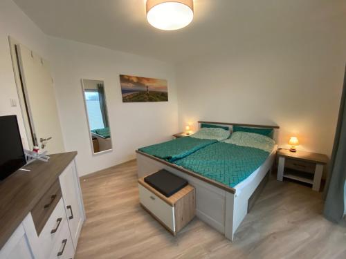 エセンスにあるBärenkoje Esensのベッドルーム1室(ベッド1台、緑の掛け布団付)