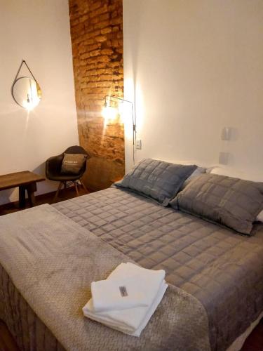 a bedroom with a bed with a table and a chair at Encanto do Pilar in Ouro Preto