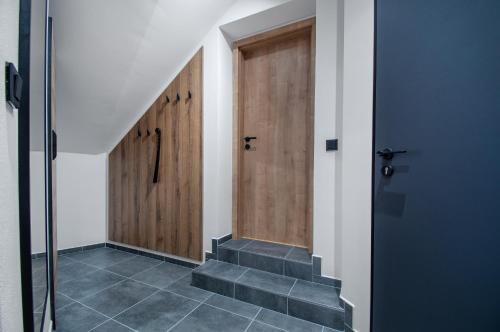 a hallway with two wooden doors and stairs at Vista Apartments in Kutná Hora