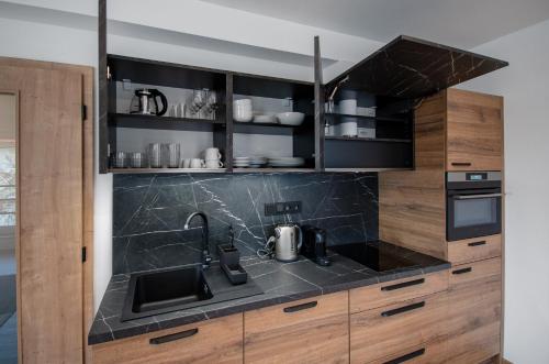 a kitchen with a black counter top and wooden cabinets at Vista Apartments in Kutná Hora