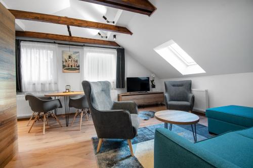 a living room with a couch and chairs and a table at Vista Apartments in Kutná Hora