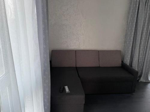 a couch sitting in a room next to a window at Гостевой дом in Chernihiv