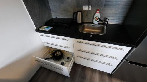 a small kitchen with a sink and white cabinets at Penzion u vody in Plzeň
