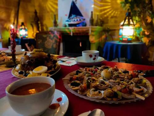 a table with a plate of food and a bowl of soup at Dar El Kasba Riad Guest House in Bizerte