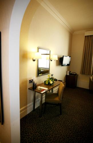 a hotel room with a desk and a mirror at The Midland Hotel in Bradford