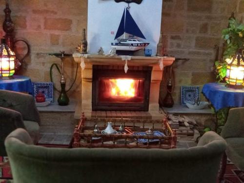 a living room with a fireplace with a boat on it at Dar El Kasba Riad Guest House in Bizerte