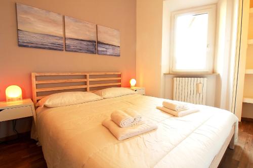 een slaapkamer met een groot wit bed en handdoeken bij Uno sguardo sul mare - appartamento in Ancona