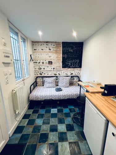 Cette chambre dispose d'un lit et d'un sol noir et blanc. dans l'établissement Studio 1 personne Toulouse Centre Jeanne d'Arc, à Toulouse