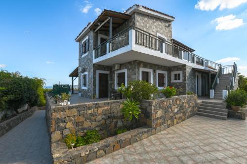 a stone house with a stone retaining wall and stairs at Villa Medusa in Hersonissos