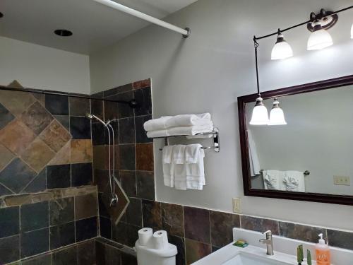 a bathroom with a shower and a sink and a mirror at Buffalo Lodge of Bigfork in Bigfork