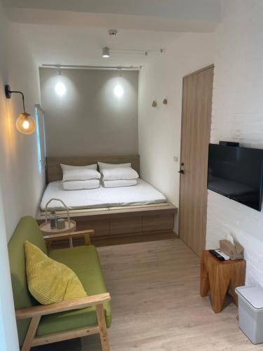 Zimmer mit einem Bett, einem Sofa und einem TV in der Unterkunft DayBreak 2 in Taitung