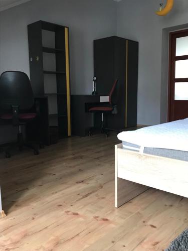 a bedroom with a bed and a desk and chairs at Затишна квартира в спальному районі in Lviv