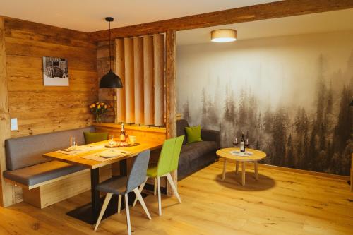 une salle à manger avec une table et des chaises vertes dans l'établissement Ferienwohnung am Dorfbach, à Rettenberg