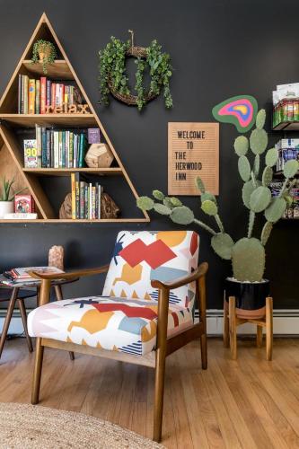 a living room with a chair and a book shelf at The Herwood Inn in Woodstock