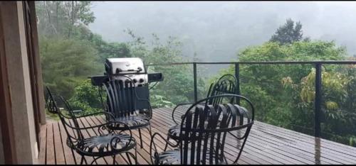 a balcony with two chairs and a camera on a deck at Benjamin Cottage Haputale in Haputale